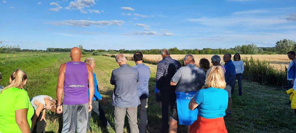 Deelnemers kijken uit over de graslanden en akkers van de Ooijpolder