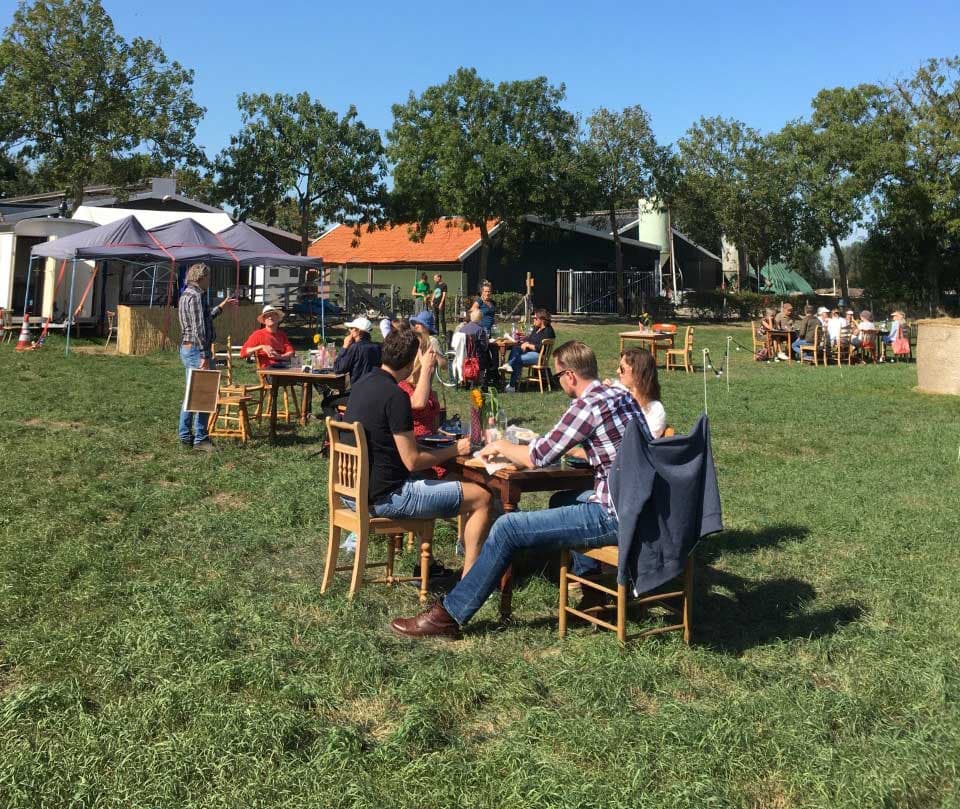 Kleine Holztische im Gras für ein informelles Event auf dem Hof