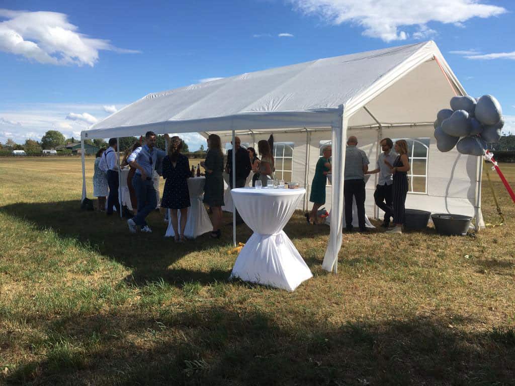 Gäste an einem weißen Festzelt auf der Wiese von Buitengast