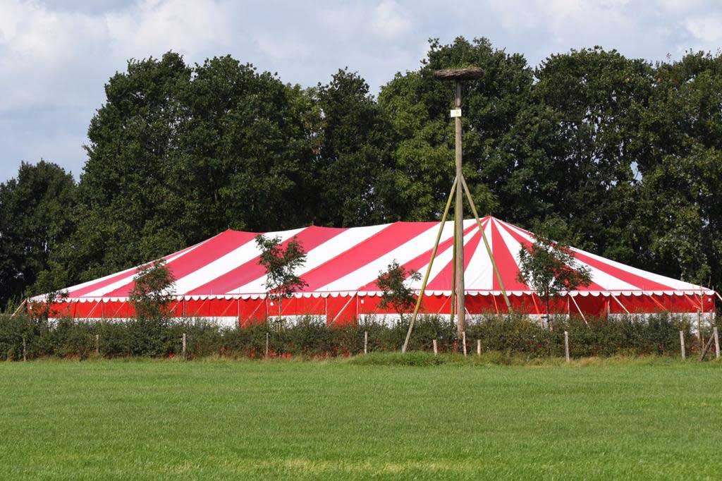 Rot-weißes Theaterzelt in der grünen Landschaft bei Buitengast